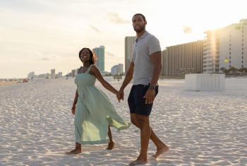 Couple walking on the beach at sunset in Orange Beach