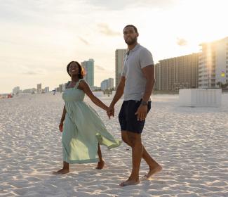 Couple walking on the beach at sunset in Orange Beach