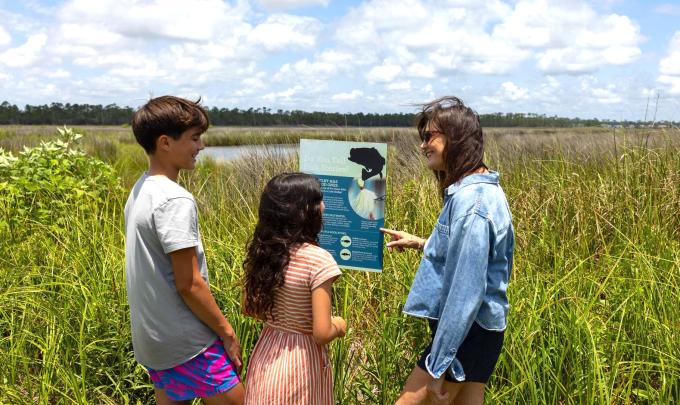 Family reading a sign inside Gulf State Park