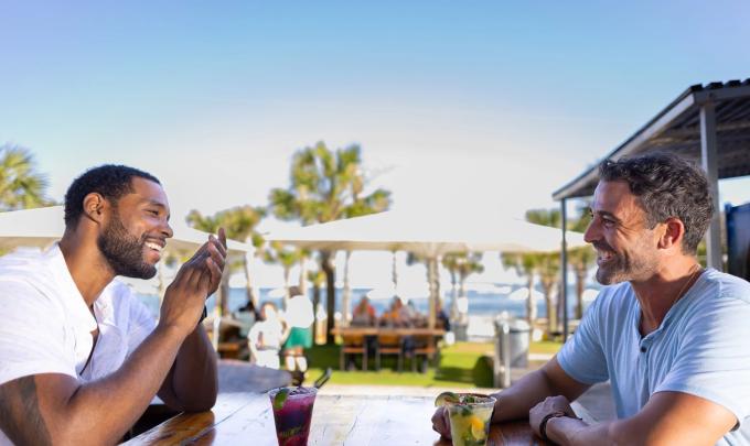 Two men sitting at a table outside at The Gulf waterfront restaurant in Orange Beach