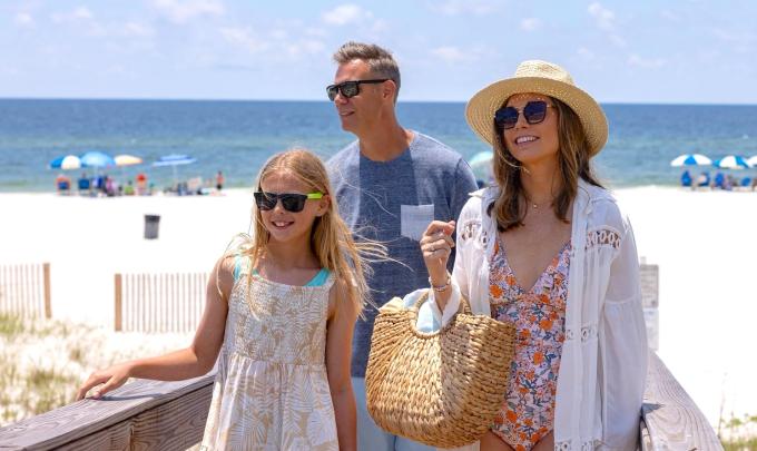 Family walking along a boardwalk on the beach in Gulf Shores