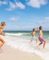 Kids running into the Gulf on the beach in Gulf Shores