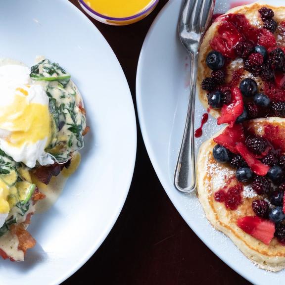 A plate of berry pancakes and eggs benedict