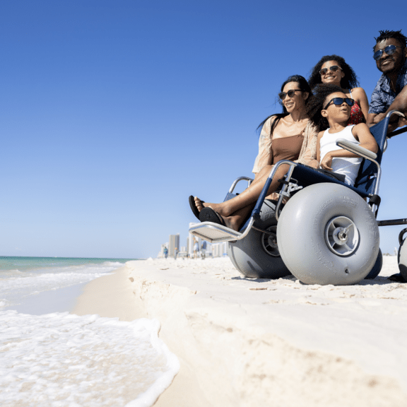 Family with beach friendly wheel chair at Alabama's beaches