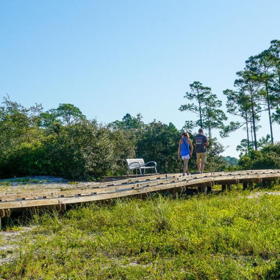 Couple walking along a boardwalk in Bon Secour National Wildlife Refuge