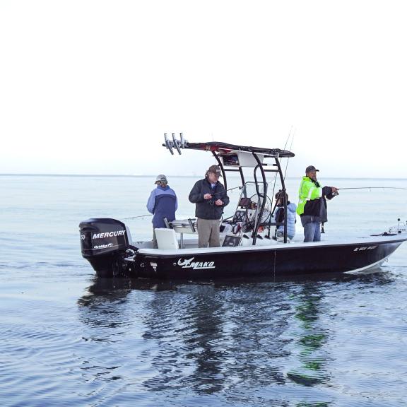 A small boat full of anglers fishing in the Gulf near oil rigs off of Gulf Shores