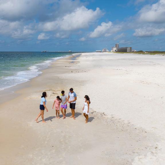 Family walking along the shore on the beach in Gulf Shores