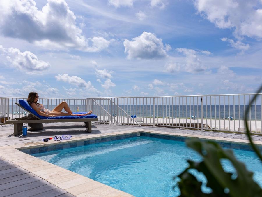 woman relaxing by a private pool at a beach house in orange beach